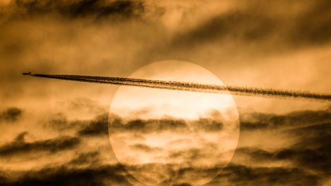 A plane flies in front of the sun. Chemicals that deplete the ozone layer, which protects us from the sun's harmful rays, are on the rise. 