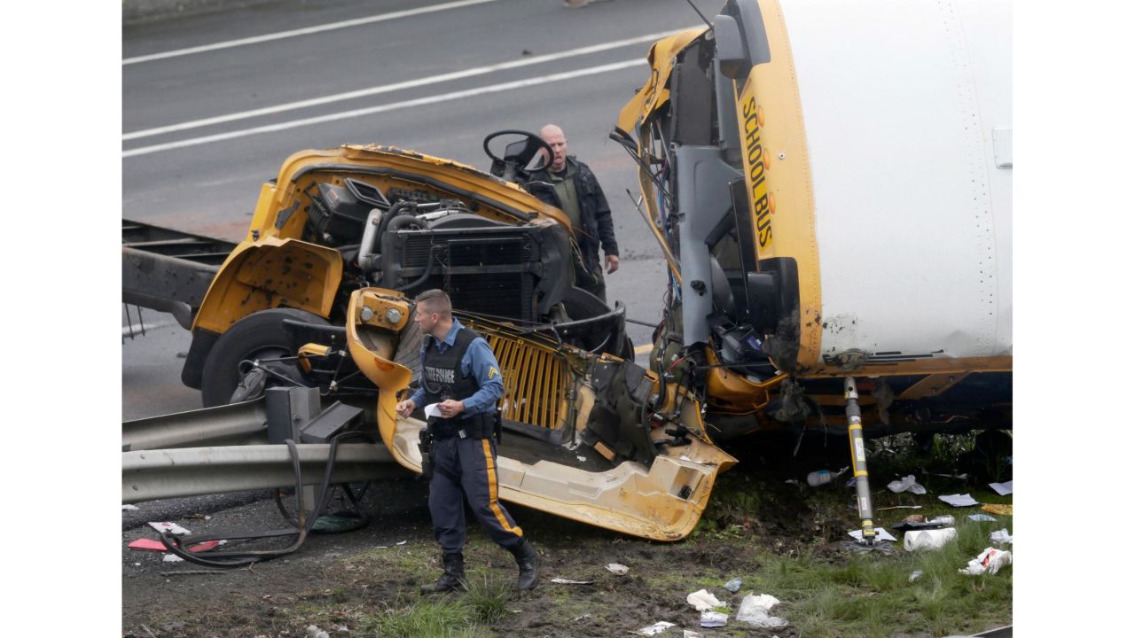 Emergency personnel work at the scene of a school bus and dump truck collision on Interstate 80 in Mount Olive Township, New Jersey.