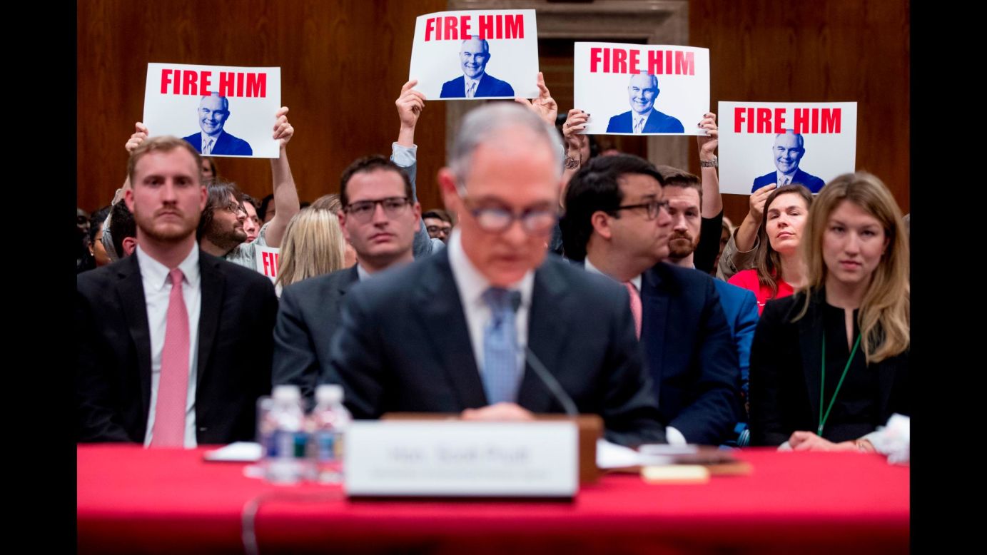 Members of the audience hold up signs as Scott Pruitt, the embattled administrator of the Environmental Protection Agency, <a href="https://www.cnn.com/2018/05/16/politics/scott-pruitt-hearing-senate/index.html" target="_blank">testifies before a Senate Appropriations subcommittee</a> on Wednesday, May 16. Pruitt vehemently defended himself while facing tough questions about his spending and alleged ethical transgressions. He said there were some decisions during his tenure he would not have made again with the benefit of hindsight, but he also denied some of the allegations against him and said some were exaggeration.