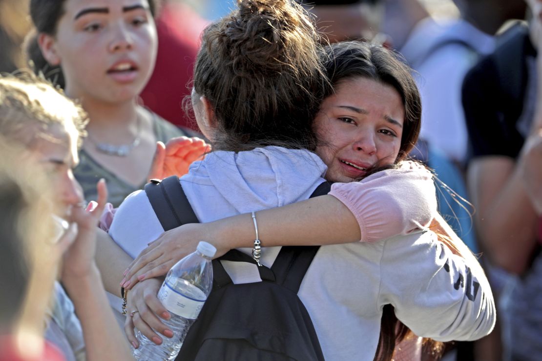 Students embrace after a February 14 shooting at Marjory Stoneman Douglas High School in Parkland, Florida.