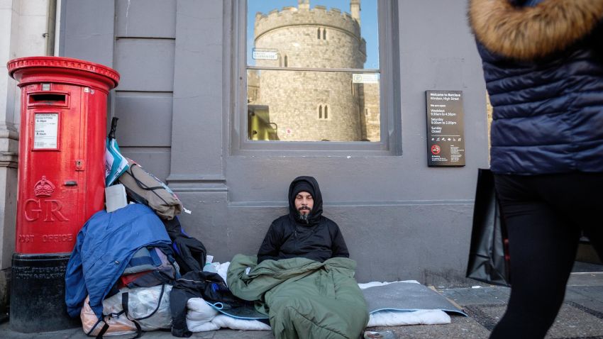 WINDSOR, ENGLAND - FEBRUARY 12:  Windsor Castle is seen in the reflection of a bank window as Sunny, a homeless man who has been on the streets of Windsor for around eight months, lays in his sleeping bag on January 5, 2018 in Windsor, England. Windsor council has faced criticism after deciding to fine rough sleepers £100 in an attempt to clear the streets, ahead of the wedding of Prince Harry and Meghan Markle on May 19.  (Photo by Leon Neal/Getty Images)
