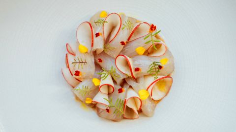 This colorful dish made of  kampachi, almond butter and nectarines can be found at Petit Crenn.