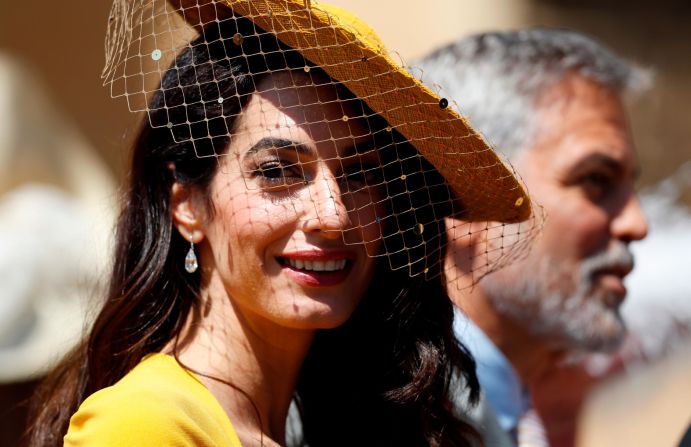 Amal and George Clooney arrive at Windsor Castle for the wedding ceremony of Prince Harry and Meghan Markle. As described by fashion commentator Caryn Franklin, Amal was radiant in an "artfully tilted canary yellow brim and matching fitted dress; a wonderful tonal choice for her complexion." The hat, designed by Stephen Jones, was also adorned with a chic sequin detailed mini-veil. "A wonderful tonal choice for her complexion," Franklin adds.