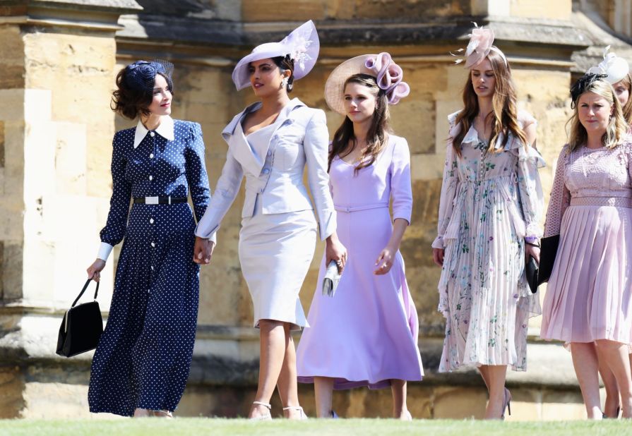 Abigail Spencer, far left, and Priyanka Chopra (wearing a Vivienne Westwood dress and a Philip Treacy hat) arrive at St George's Chapel at Windsor Castle.