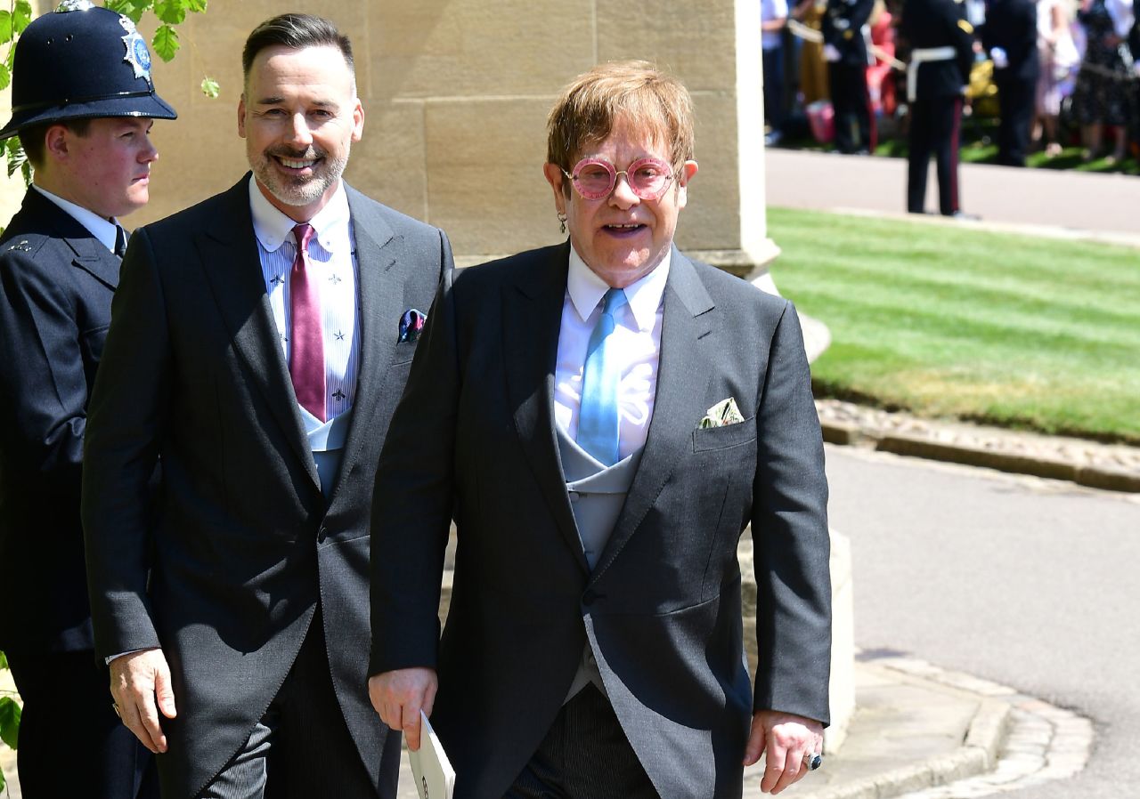 British singer-songwriter Elton John, right, and husband David Furnish leave after attending the wedding ceremony of Prince Harry and Meghan Markle on Saturday, May 19.