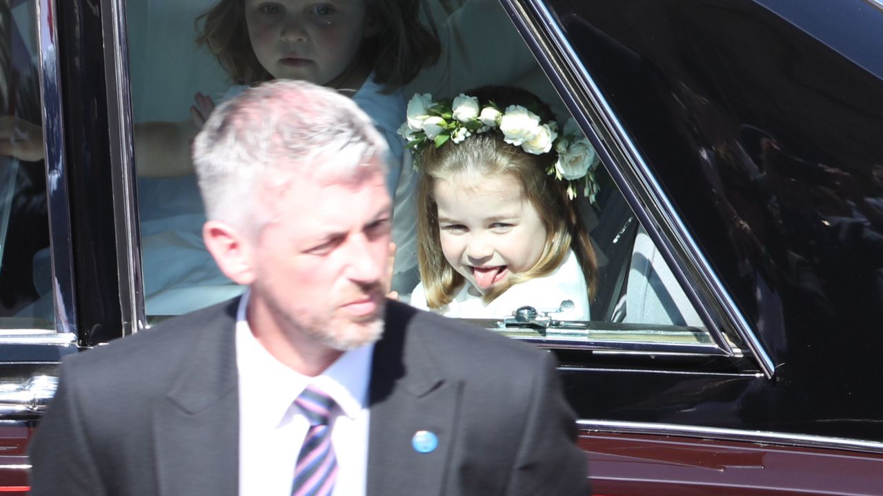 Princess Charlotte, sticking out her tongue, arrives at the wedding ceremony.