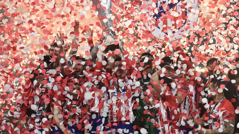 Atletico Madrid players celebrate with the trophy after the UEFA Europa League final football match between Olympique de Marseille and Club Atletico de Madrid at the Parc OL stadium in Decines-Charpieu, near Lyon, on Wednesday, May 16. 