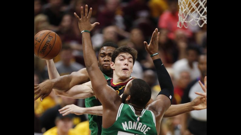 Cleveland Cavaliers forward Cedi Osman, center, of Turkey is fouled as he goes to the basket between Boston Celtics forward Guerschon Yabusele, back, of France and the Celtics' Greg Monroe, front, during the second half of Game Three of the Eastern Conference Finals at Quicken Loans Arena in Cleveland on Saturday, May 19.