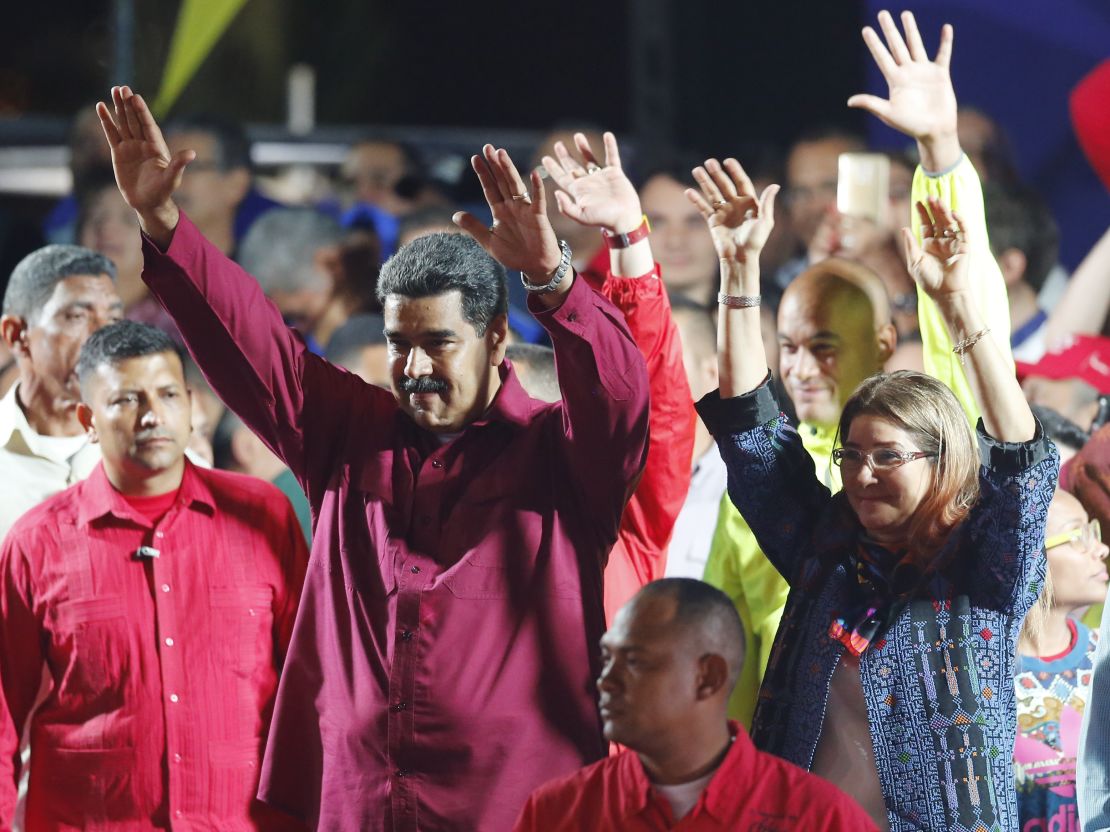 Venezuela's President Nicolas Maduro and his wife, Cilia Flores, wave to supporters at the presidential palace in Caracas. 