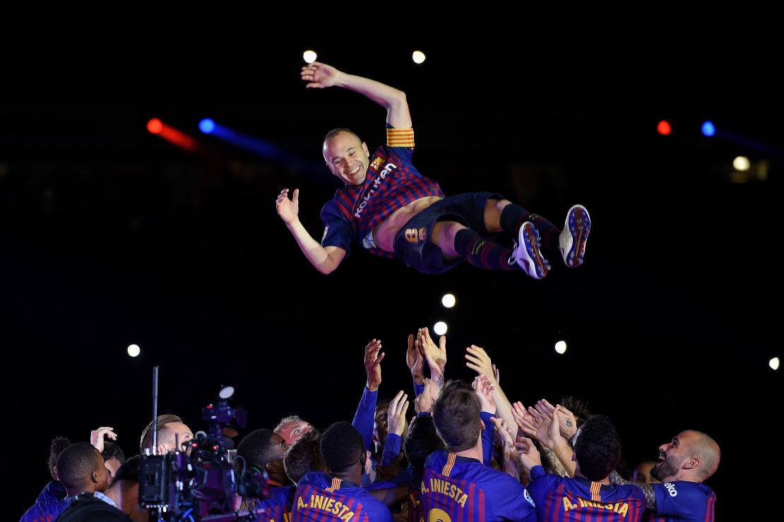 The departing midfielder's Barcelona teammates all wore shirts adorned with "Iniesta 8," before throwing him into the air. 