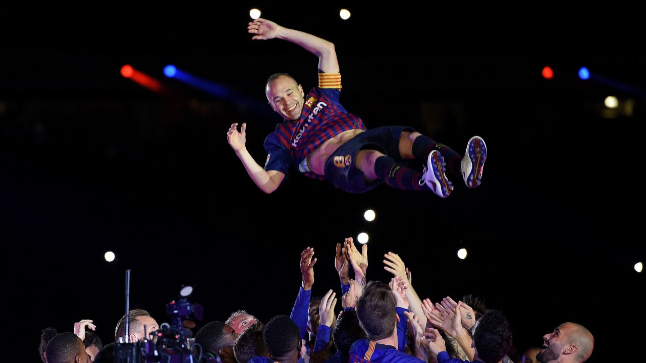The departing midfielder's Barcelona teammates all wore shirts adorned with "Iniesta 8," before throwing him into the air.