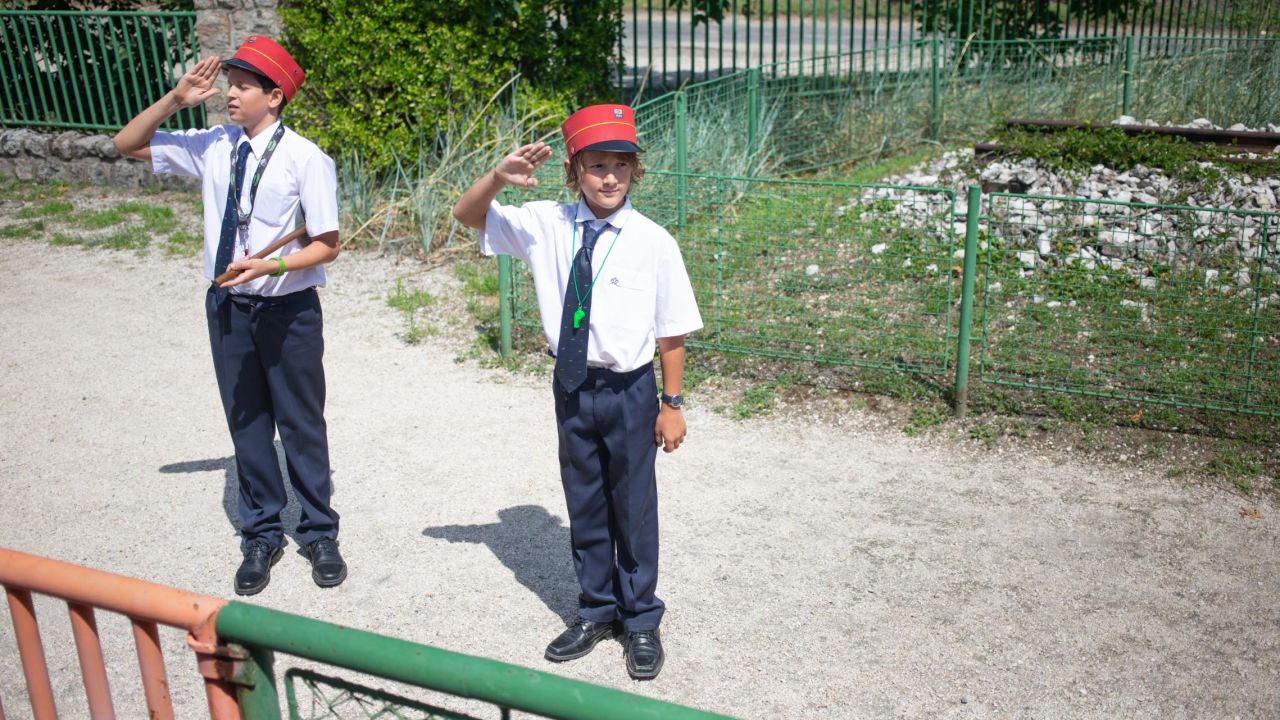 <strong>Salutes and smiles: </strong>The children wear smart railway uniforms in the railway's red, white and blue colors.