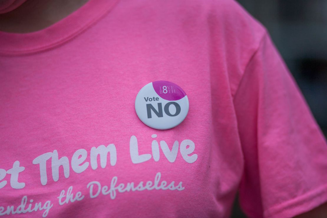 Faulkner wears an Irish 'Vote NO' badge on her Let Them Live shirt. Faulkner says the group's shirts were designed in pink to "reappropriate the color pink back from Planned Parenthood."