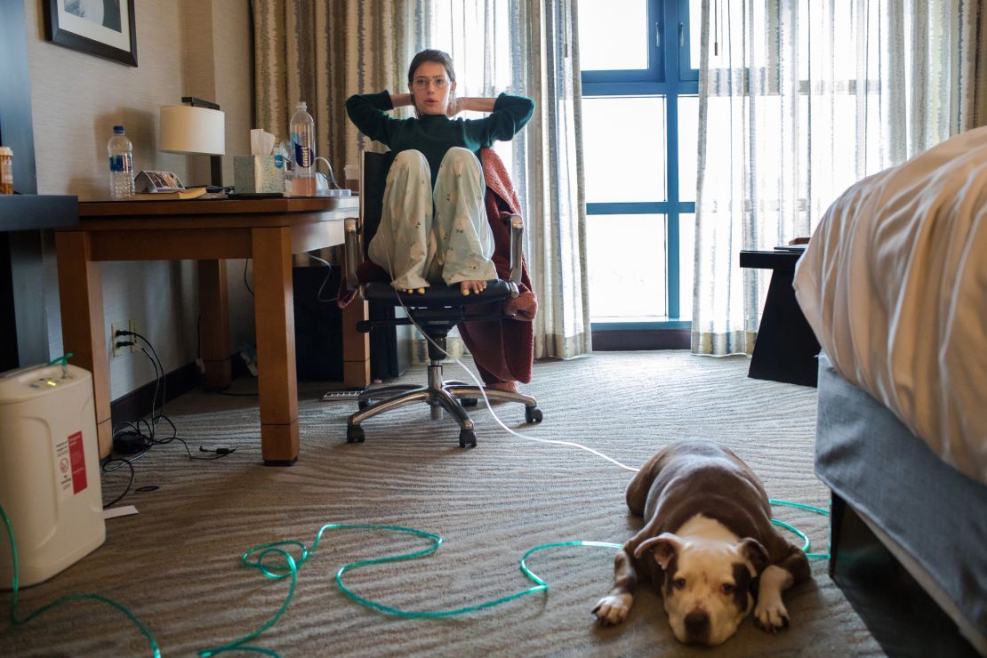 Claire Wineland sits in her hotel room with dog Daisy before heading to evaluations at the Center for Transplantation at UC San Diego Health.