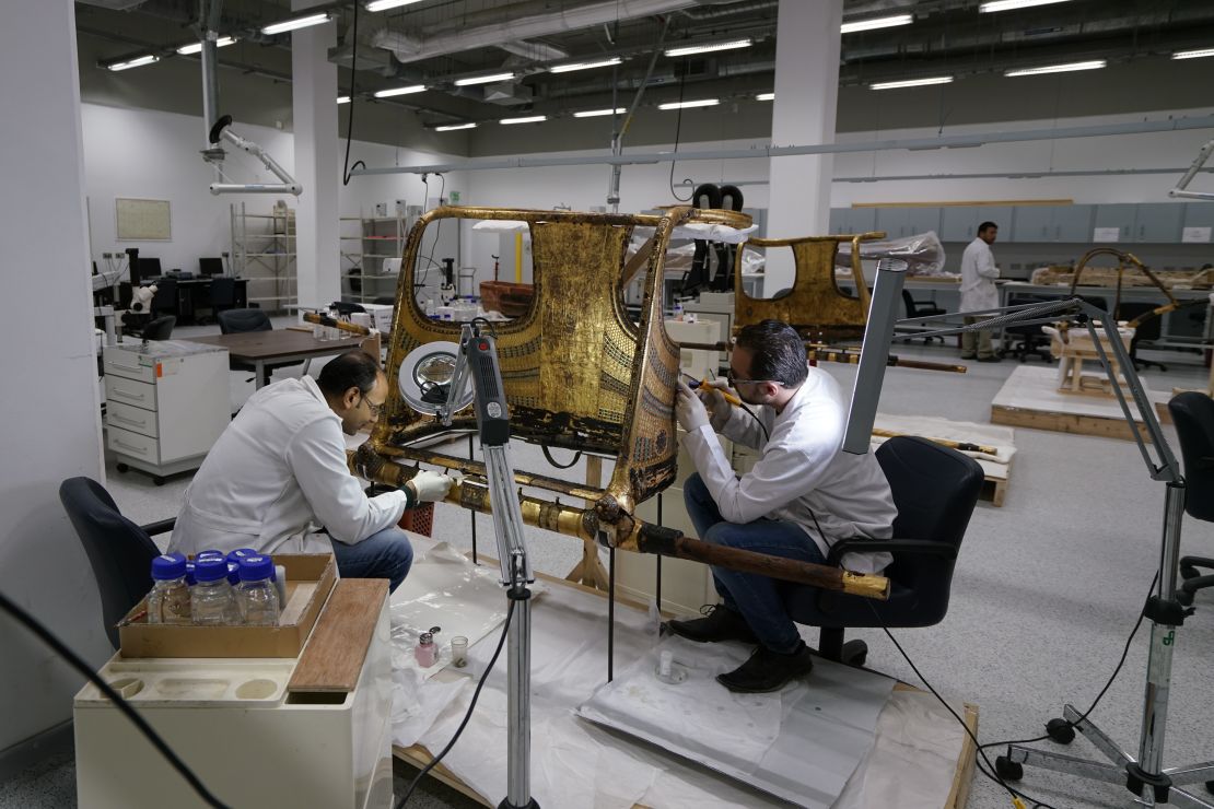 Conservators work on the restoration of a chariot from Tutankhamun's tomb at the Wood Laboratory in the Grand Egyptian Museum's conservation center. 