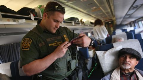 A Border Patrol agent checks passenger identifications in 2013 aboard an Amtrak train in Depew, New York -- more than 10 miles from the border.