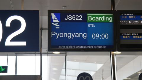 A departure screen shows "Pyongyang" as the journalists' destination, but they ended up flying to Wonsan. 