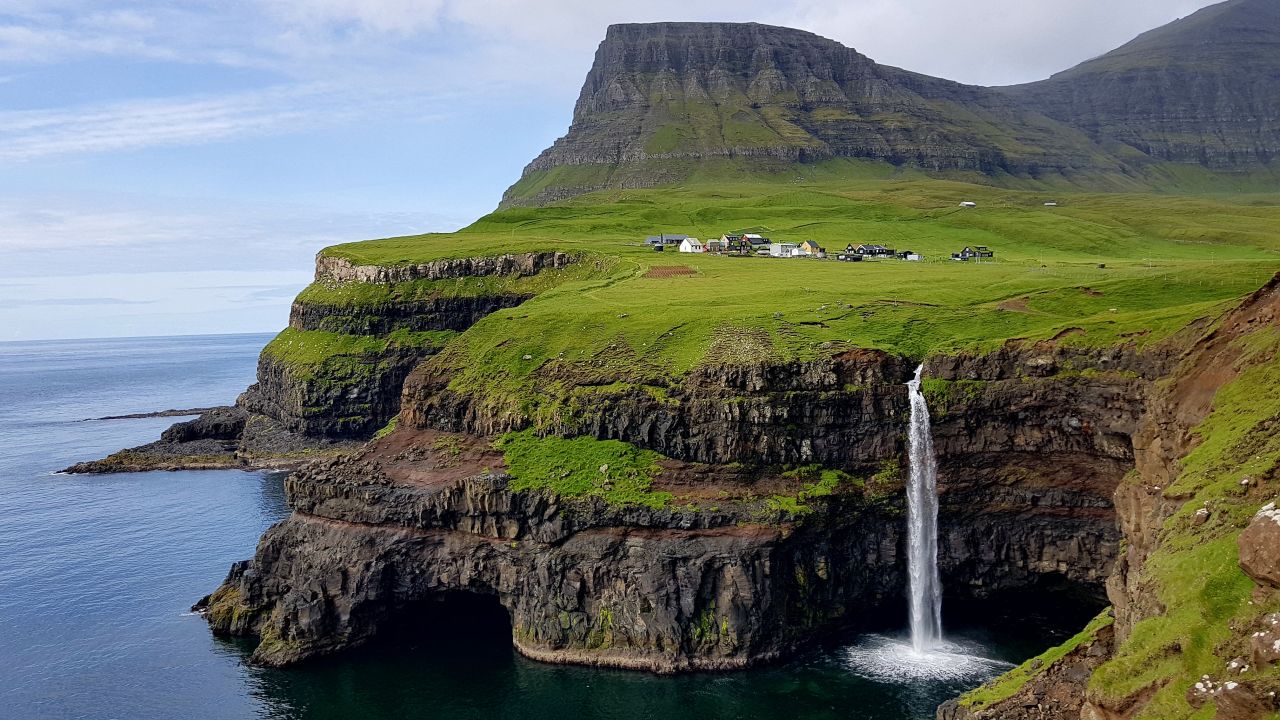 <strong>Faroe Islands:</strong> Cut off by the mountains, Gásadalur is a remote escape with a seaside view in the Danish Faroe Islands.