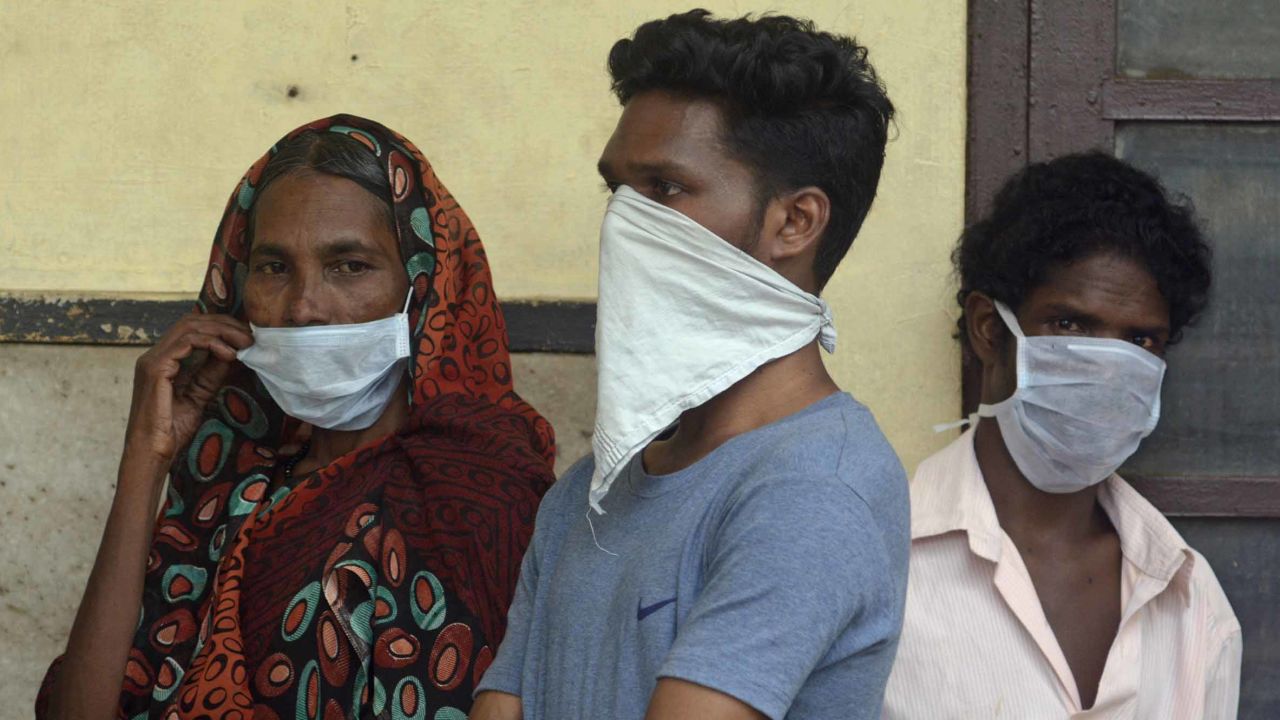 Indians standing in a queue outside the Government Medical College hospital in Kozhikode wear masks as a precaution against the Nipah virus.