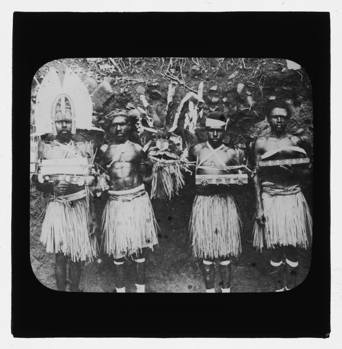 Four Torres Strait men in traditional dress and holding ceremonial objects on Hammond Island in 1905, photographed by Otto Watson.