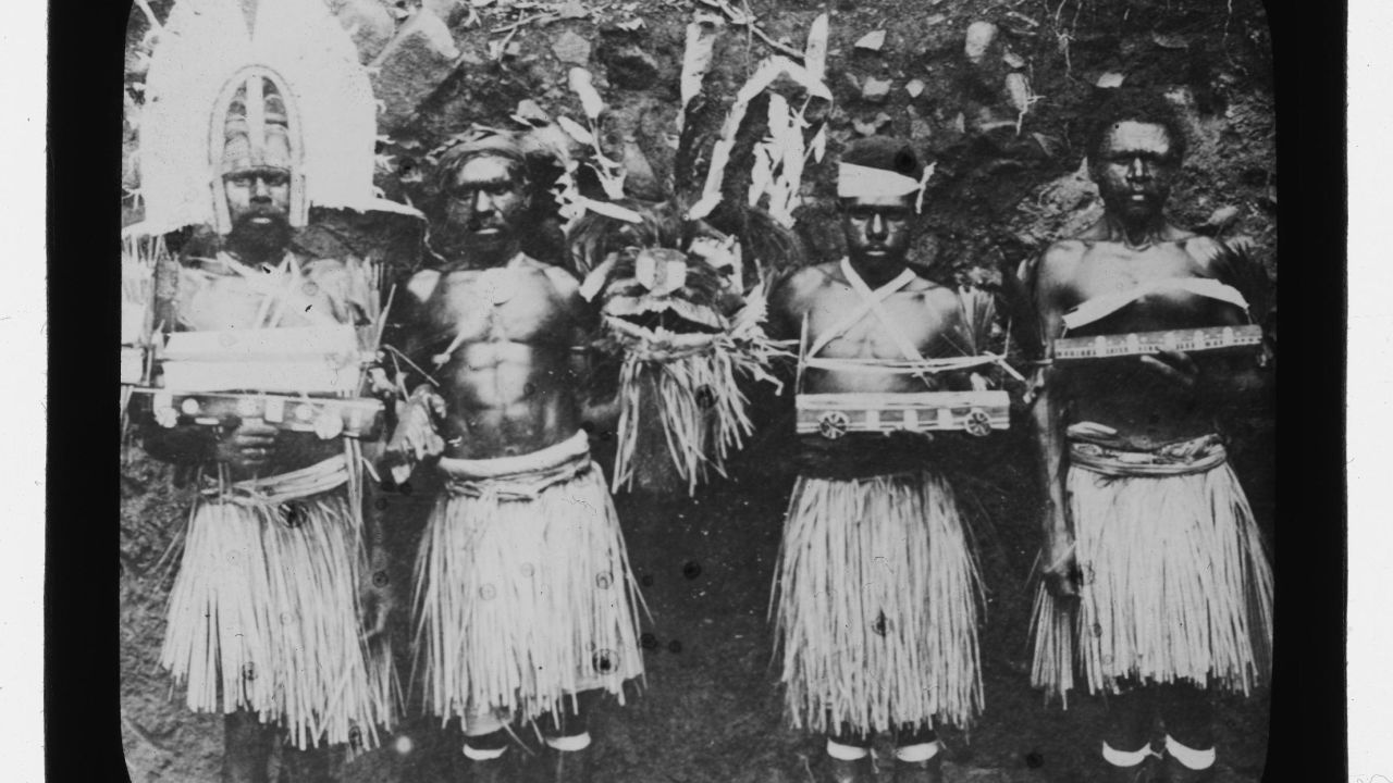 Four Torres Strait men in traditional dress and holding ceremonial objects on Hammond Island in 1905, photographed by Otto Watson.