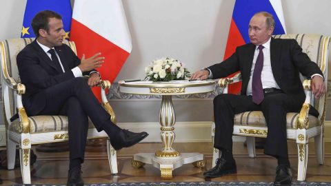 Putin and Macron speak at a meeting ahead of their press conference.