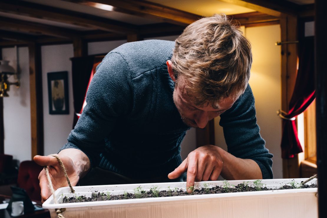 Dennis Lyngsø observes plants that have begun sprouting on board.
