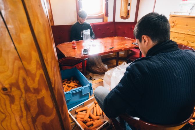 Crew peel carrots in the Linden's saloon after another outbreak of rot -- keeping food fresh on board is challenging and a learning process.