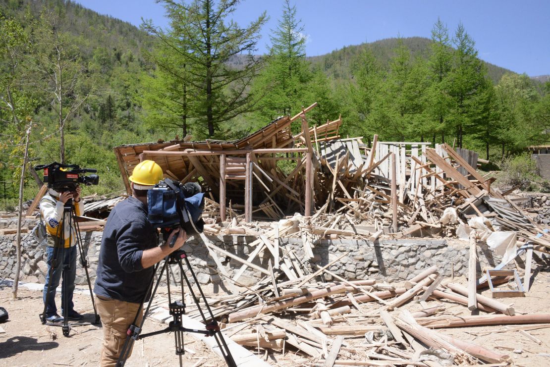 Journalists film the Punggye-ri nuclear site after the tunnels are detonated.