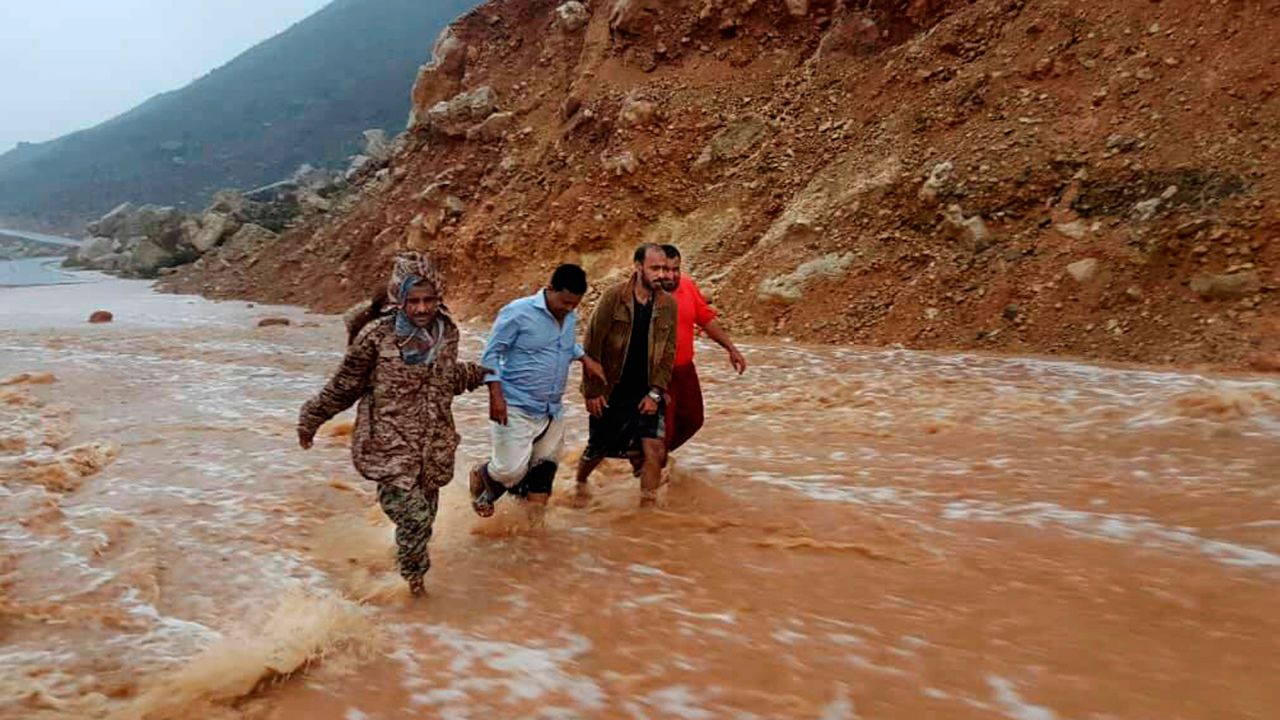 Men walk on a flooded road Thursday as rain and winds from Cyclone Mekunu hit  the island of Socotra.