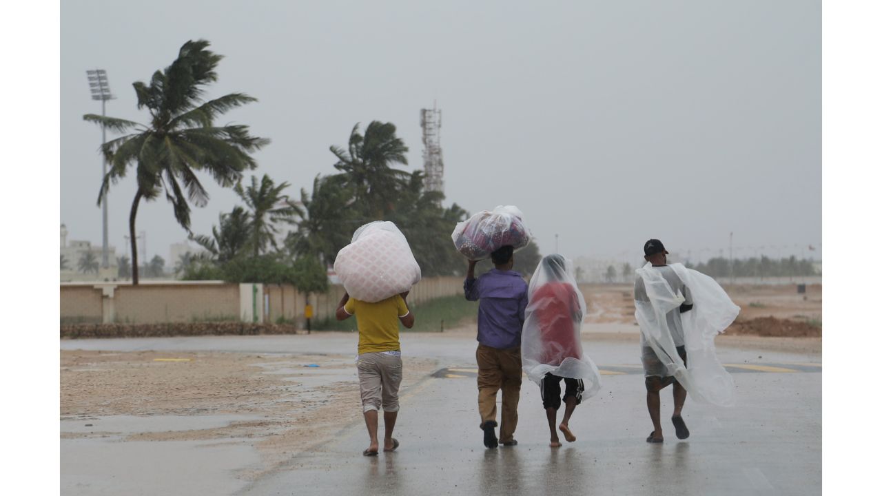Workers walk to their camp under the rain in Salalah, Oman, on Friday.