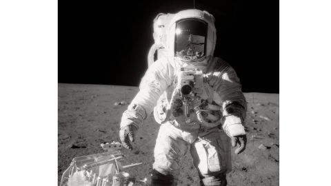 Bean pauses near a tool carrier during the Apollo 12 spacewalk on the moon's surface.