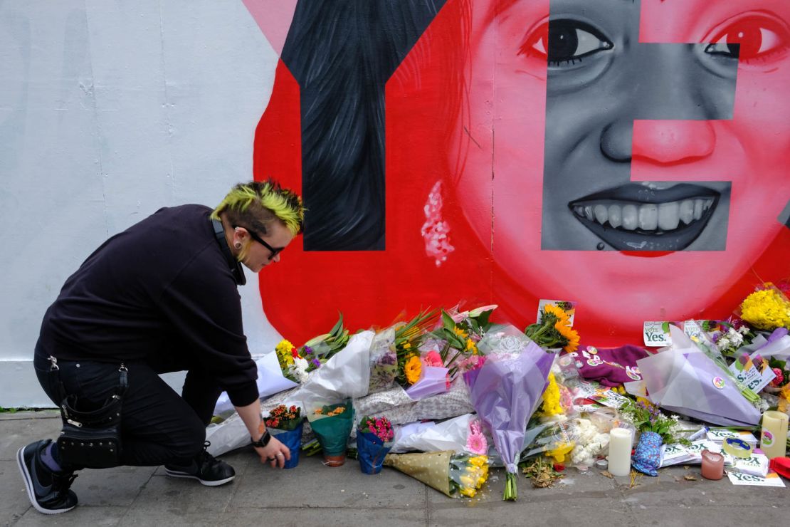 A woman leaves flowers at the Savita Halappanavar mural in Dublin on Saturday.