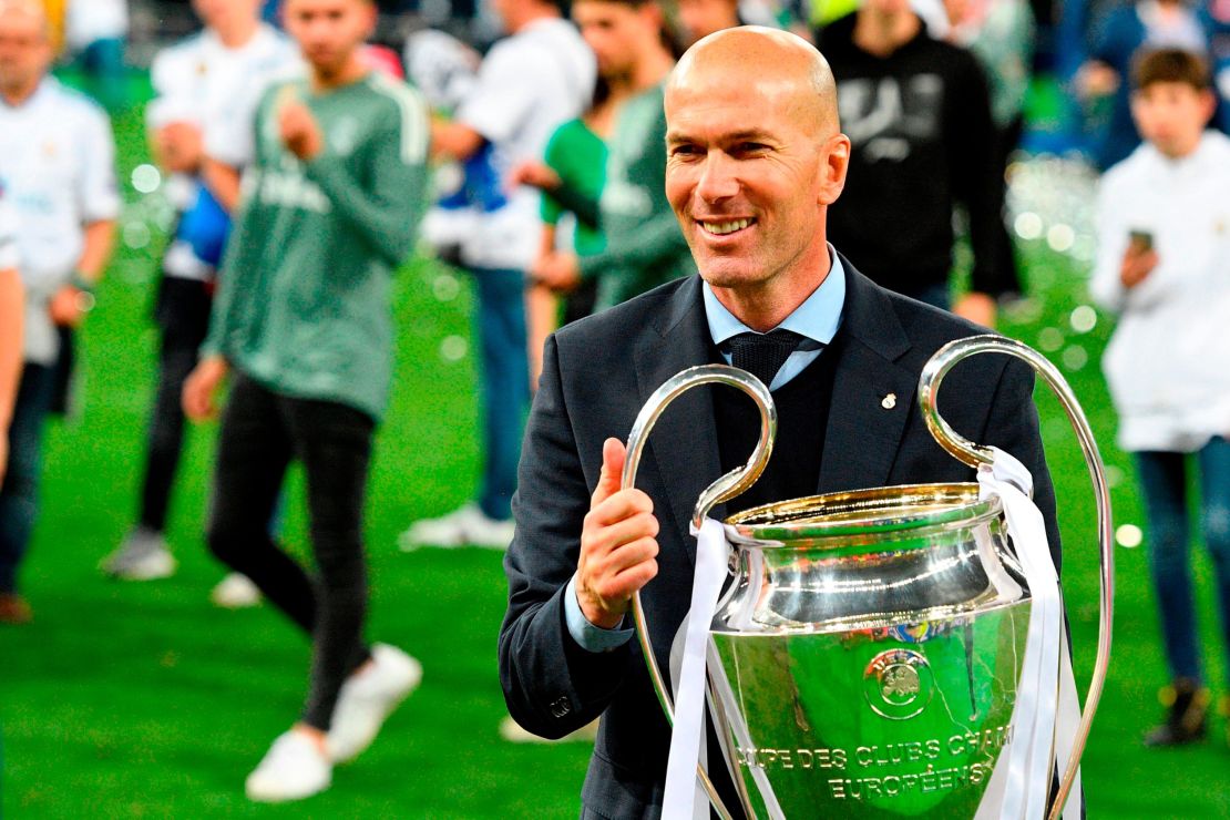 Real Madrid's French coach Zinedine Zidane poses with the trophy after winning  the UEFA Champions League final  against Liverpool.