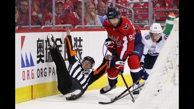 A linesman is upended as Evgeny Kuznetsov (92) of the Washington Capitals and Ondrej Palat (18) of the Tampa Bay Lightning vie for possession in game six of the Eastern Conference Finals during the 2018 NHL Stanley Cup Playoffs in Washington, DC, on Monday, May 21.