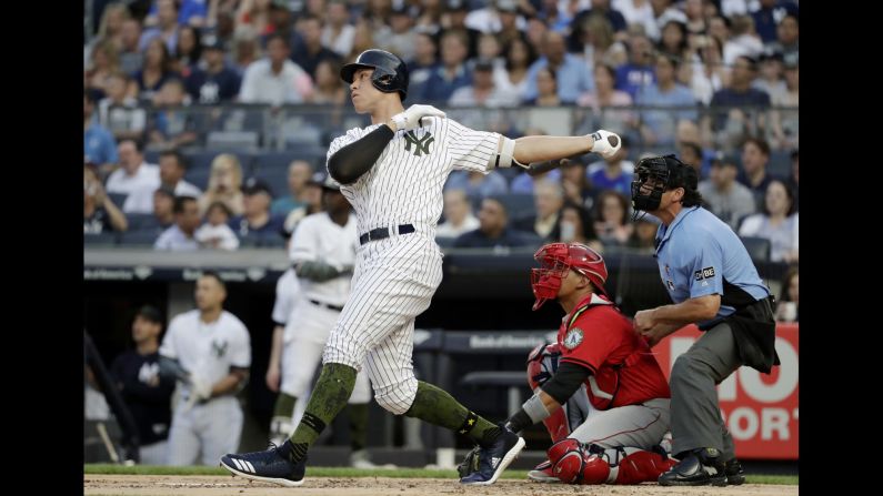 New York Yankees' Aaron Judge follows through on a home run as Los Angeles Angels catcher Jose Briceno and  umpire Phil Cuzzi watch on Saturday, May 26, in New York City.