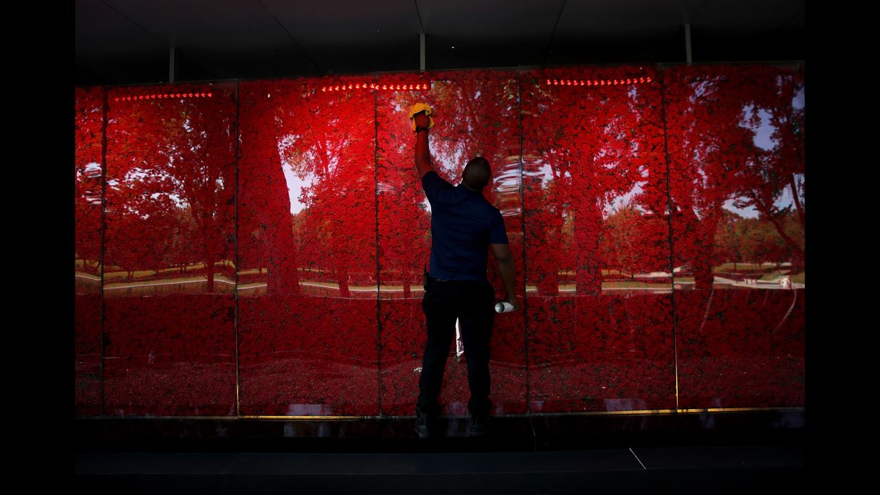 Romel Martin cleans glass panels while assisting with the installation of a temporary pop-up "Poppy Memorial" on the National Mall near the Lincoln Memorial in advance of Memorial Day May 25, 2018 in Washington, DC. (Win McNamee/Getty Images)