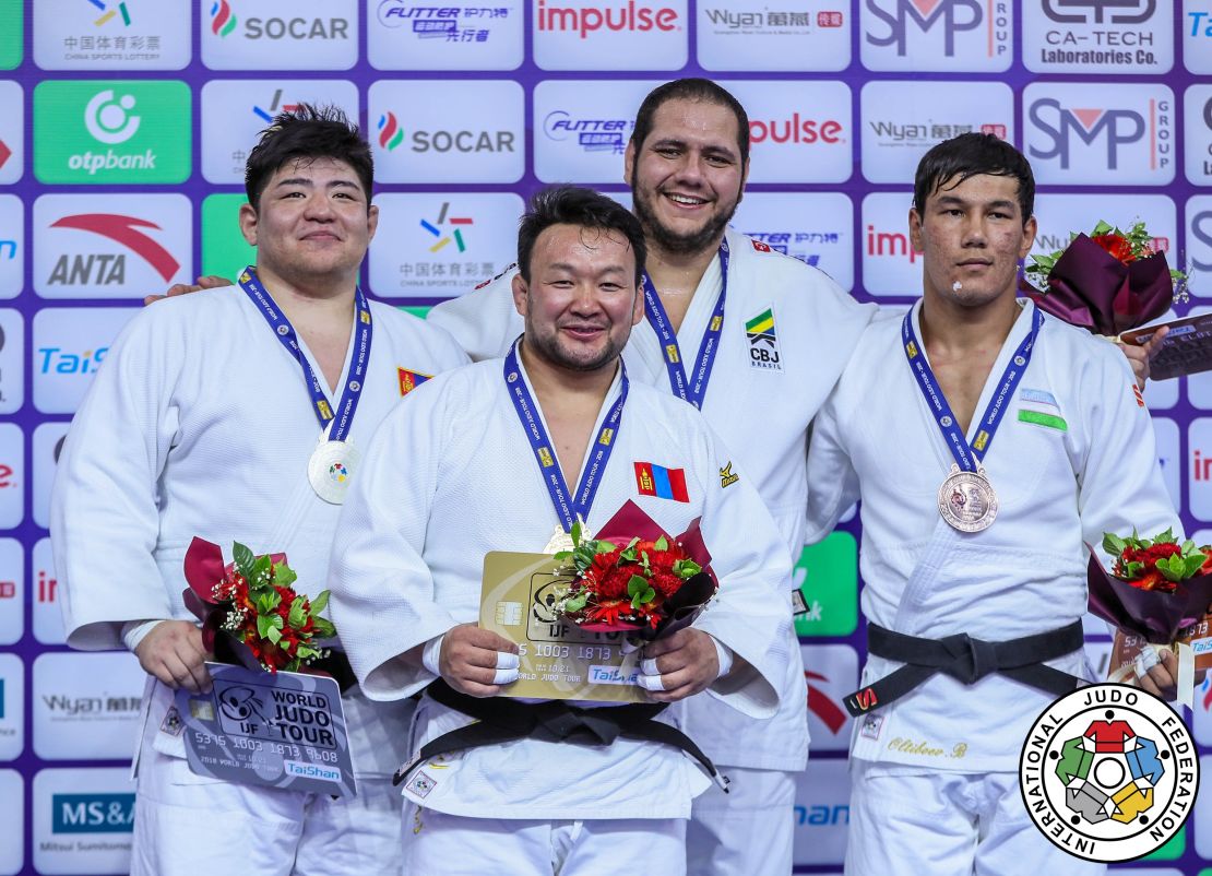 Naidan (C) stands atop the podium with Ulziibayar (L), Brazil's Rafael Silva and Uzbekistan's Bekmurod Oltiboev (R).