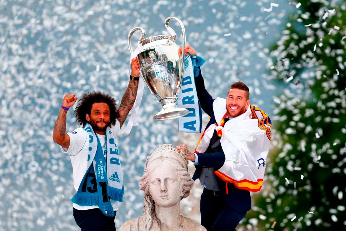 Marcelo and Sergio Ramos hold the Champions League trophy at Cibeles square in Madrid.