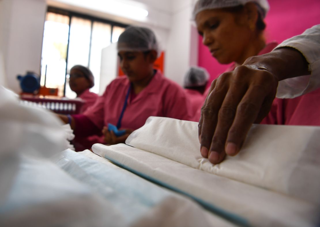Women working at the Myna Mahila Foundation preparing sanitary pads.