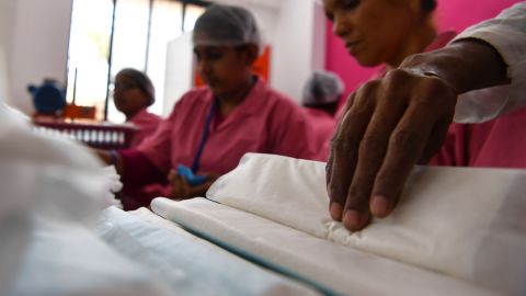 Women working at the Myna Mahila Foundation preparing sanitary pads.