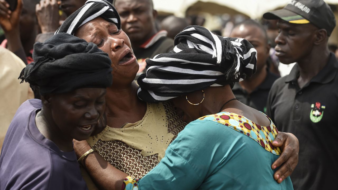 A woman cries as she consoles a widow during a funeral service for people killed in clashes between cattle herders and farmers on January 11, 2018 in Nigeria's Benue state.