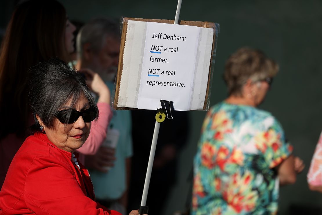 A protester holds a sign outside of a casual "Coffee and Conversation" with U.S. Rep. Jeff Denham (R-CA) at the Riverbank Teen Center on May 9, 2017 in Riverbank, California.