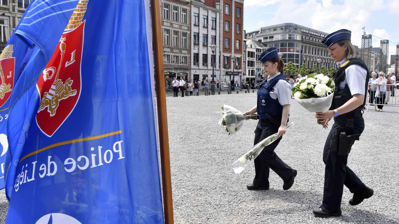 Police prepare to lay flowers on a memorial in Liege, Belgium, a day after a gunman killed three people, including two policewomen.