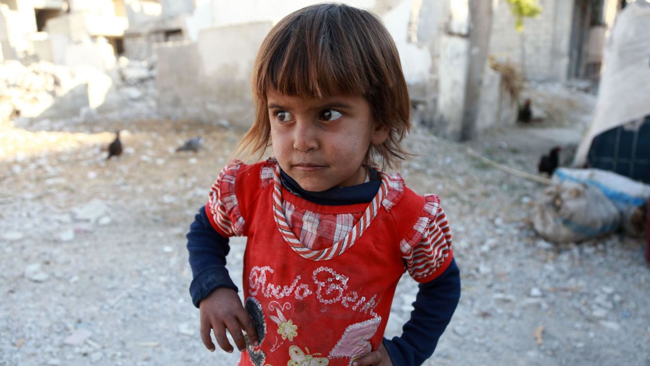 A Syrian child looks on in a heavily damaged area where her family took refuge in the rebel-held town of Saqba, in Eastern Ghouta on October 24, 2017.