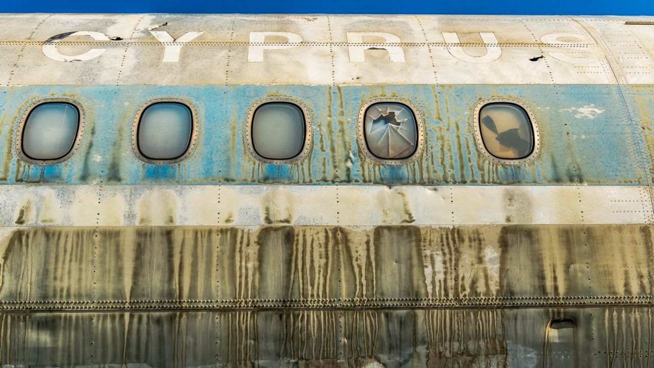 A discared passenger plane left to rot on the runway.
