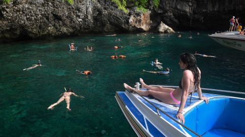 Tourists snorkel in the water near Maya Bay. 