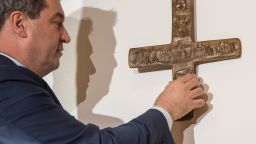 This picture taken on April 24, 2018 in Munich shows Markus Soeder, Bavarian State Premier, as he hangs a cross in the entrance area of the Bavarian State Chancellery. - The premier of Germany's Bavaria state sparked an uproar Wednesday, April 25, 2018, after his cabinet ordered that Christian crosses be fixed in the entrance halls of all public buildings. (Photo by Peter Kneffel / dpa / AFP) / Germany OUT        (Photo credit should read PETER KNEFFEL/AFP/Getty Images)