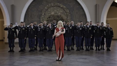 Britt Harris holds her baby girl while the troops behind her stand in solidarity.