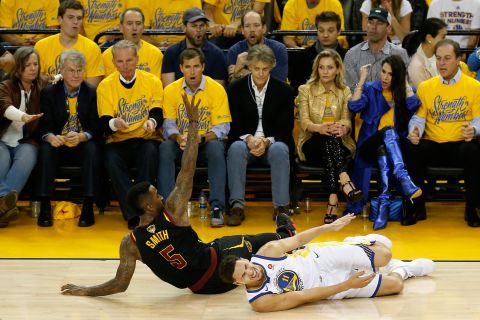 Klay Thompson grimaces in pain after Smith fell into his knee during the first quarter of Game 1. Thompson left the game briefly but returned.
